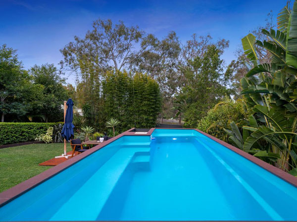 A container pool set in a lush, suburban garden