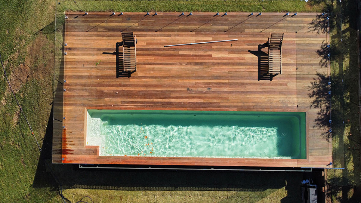 Aerial shot of a container pool with a deck, set on grass.