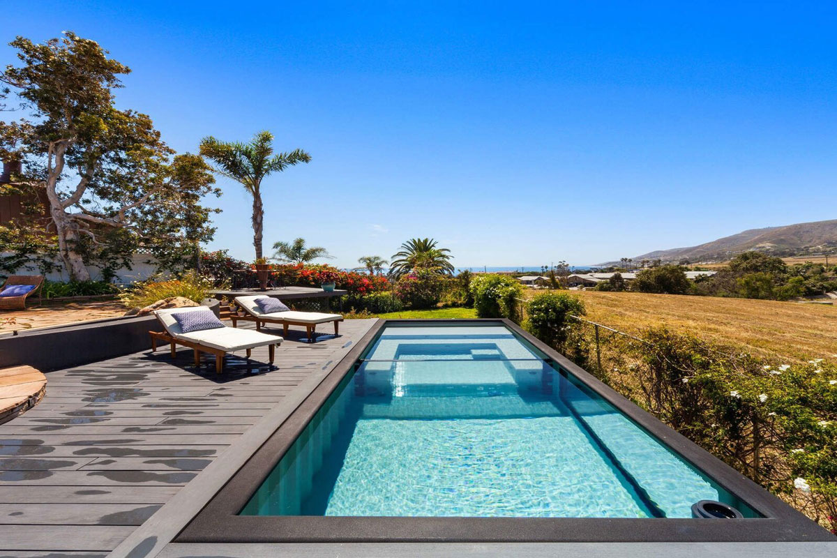 A container pool in a backyard, beneath a palm tree. Source: dwell.com