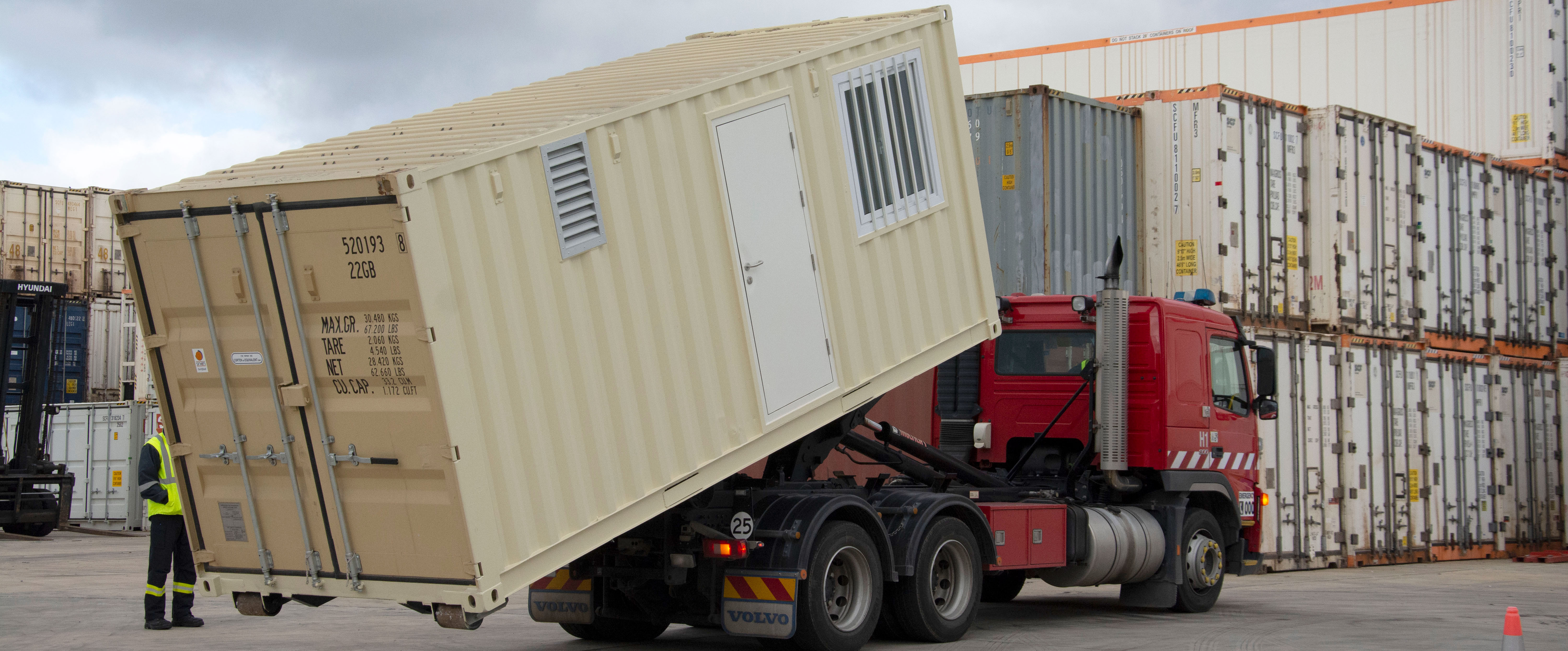 A mobile shed being loaded onto a truck